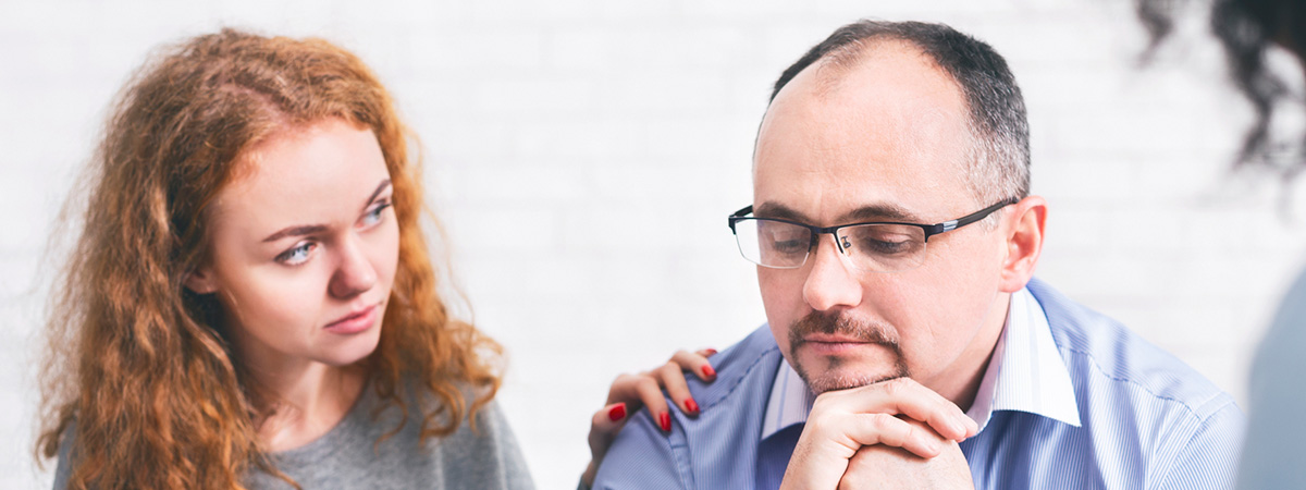 Supportive wife comforting husband with TRD during a meeting with a counselor in Millbury.