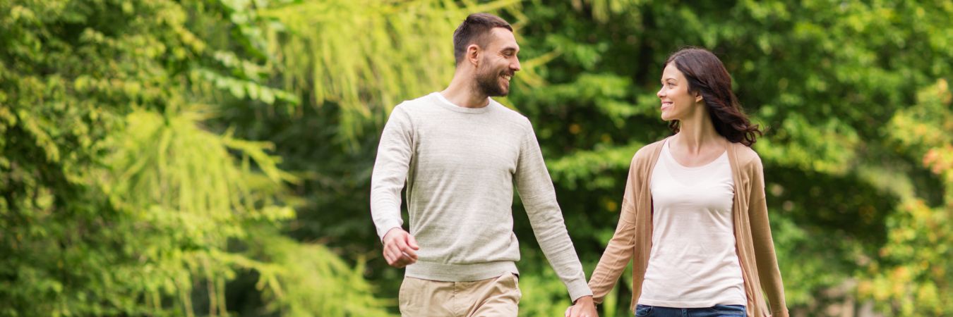 A couple walking hand in hand at a park during summer season enjoying life after rehab in Millbury